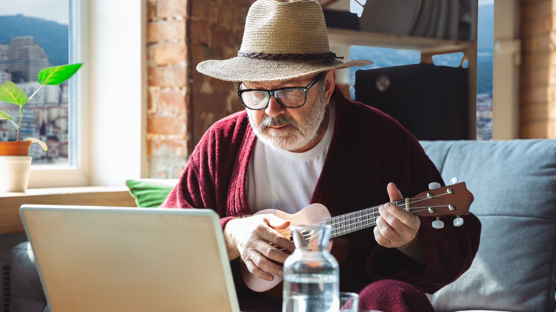 Senior man happily learning ukulele online with Inclusee.
