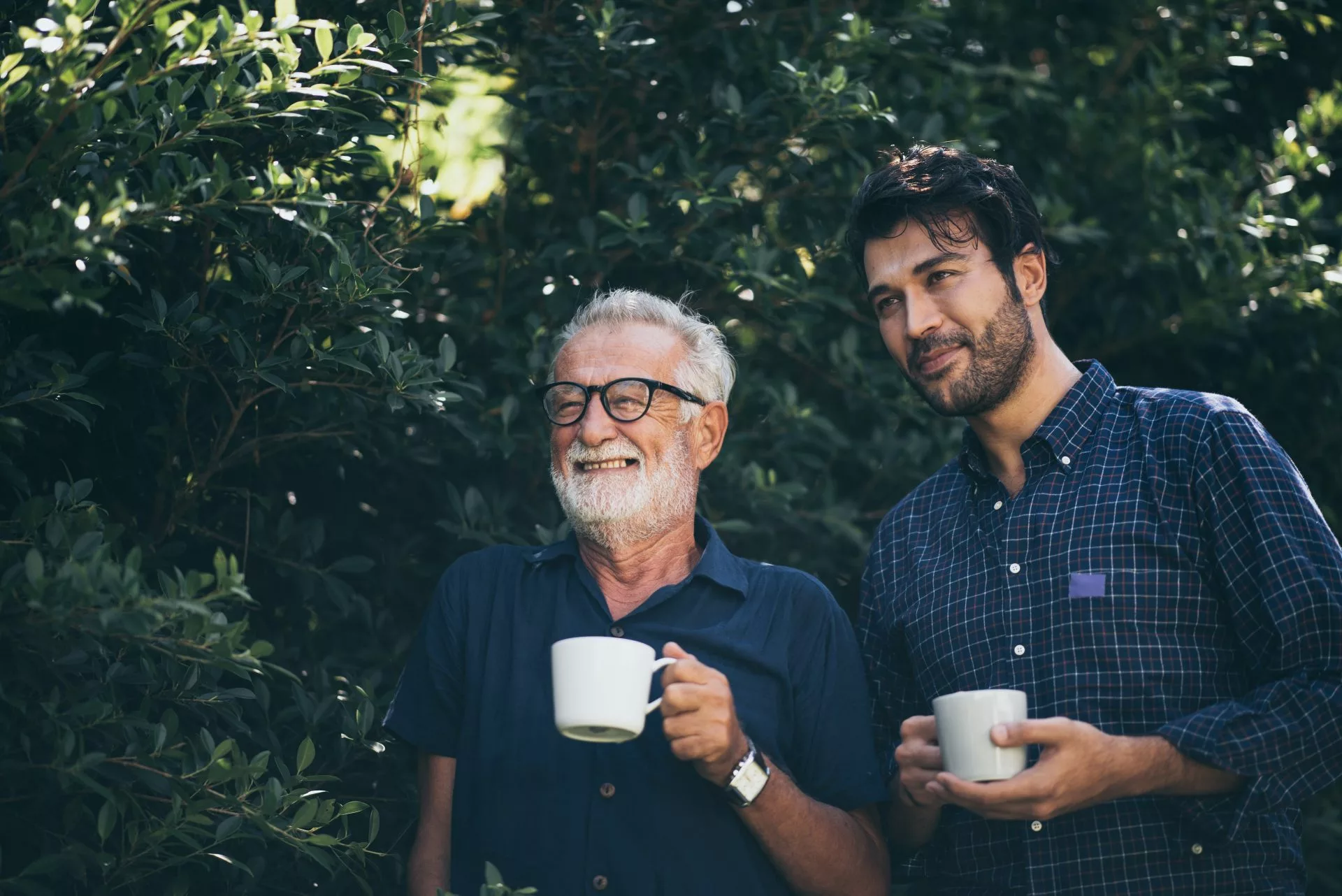 Two men sharing stories holding a coffee cup
