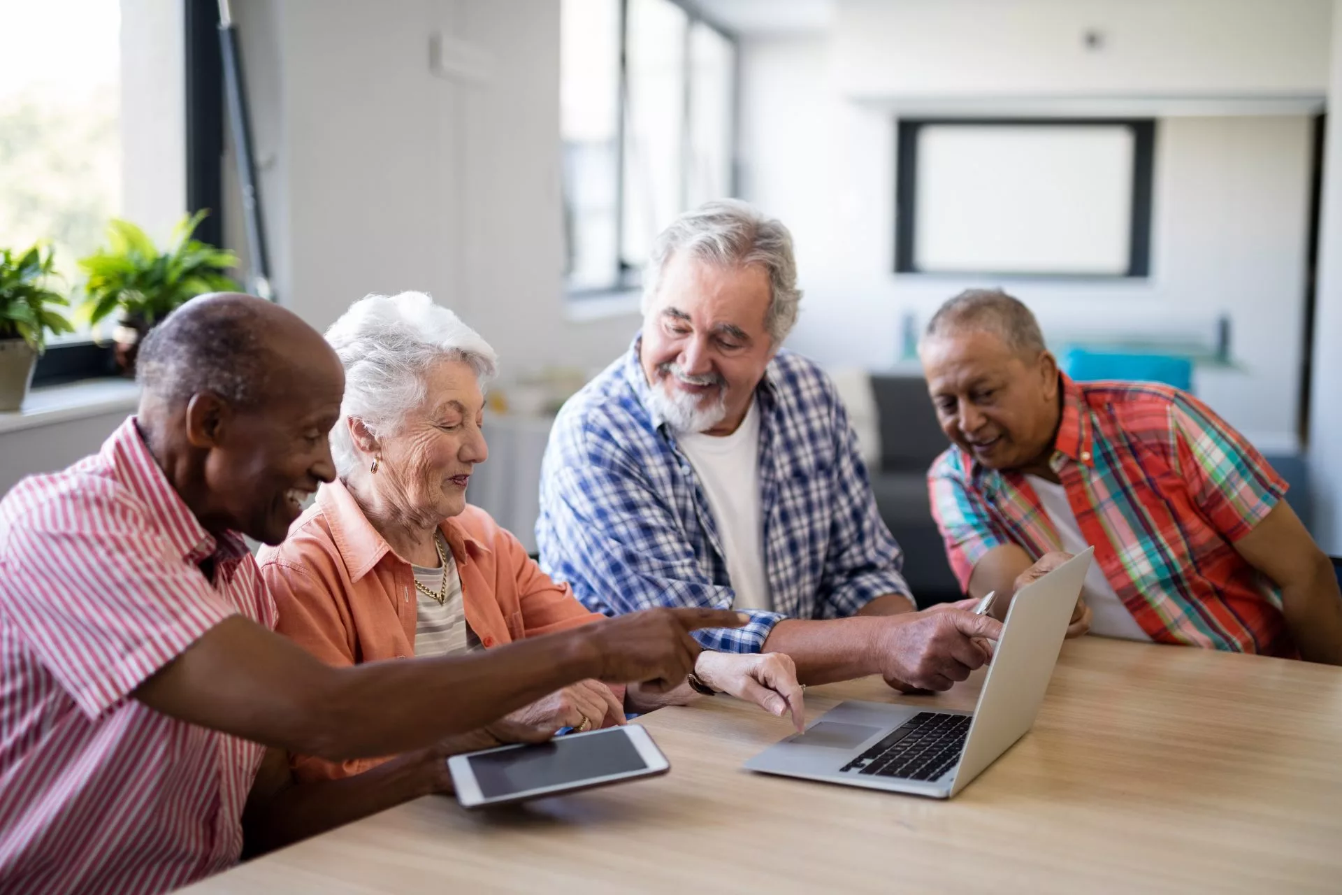 Photo of a group of seniors sitting in front of a laptop