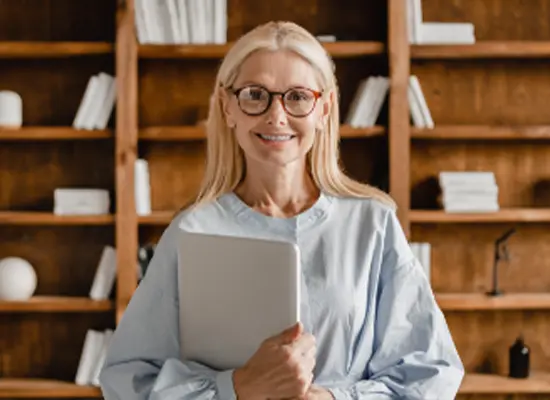 Confident senior holding a laptop.